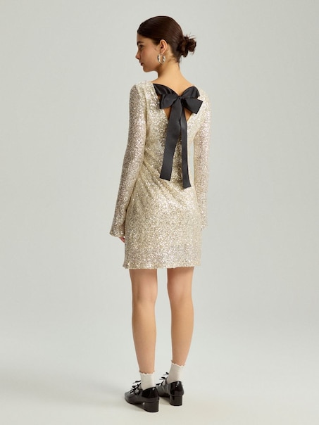 Cekinowa sukienka mini z wielką kokardą na plecach