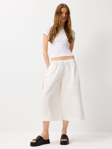 Białe spodnie baggy o fasonie cropped