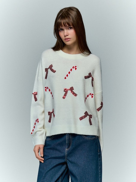 Wzorzysty kremowy sweter z kokardkami i laskami cukrowymi