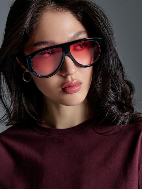 Okulary przeciwsłoneczne z grubymi czarnymi oprawkami i różowymi szkłami