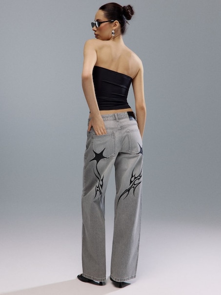 Jasnoszare jeansy boyfriend fit z motywem tribal i gwiazdkami na tyle