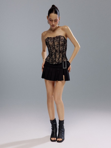 Plisowana czarna spódniczka mini z wszytymi spodenkami i sprzączką